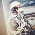 Contractor on job site using smartphone with VoIP business phone app